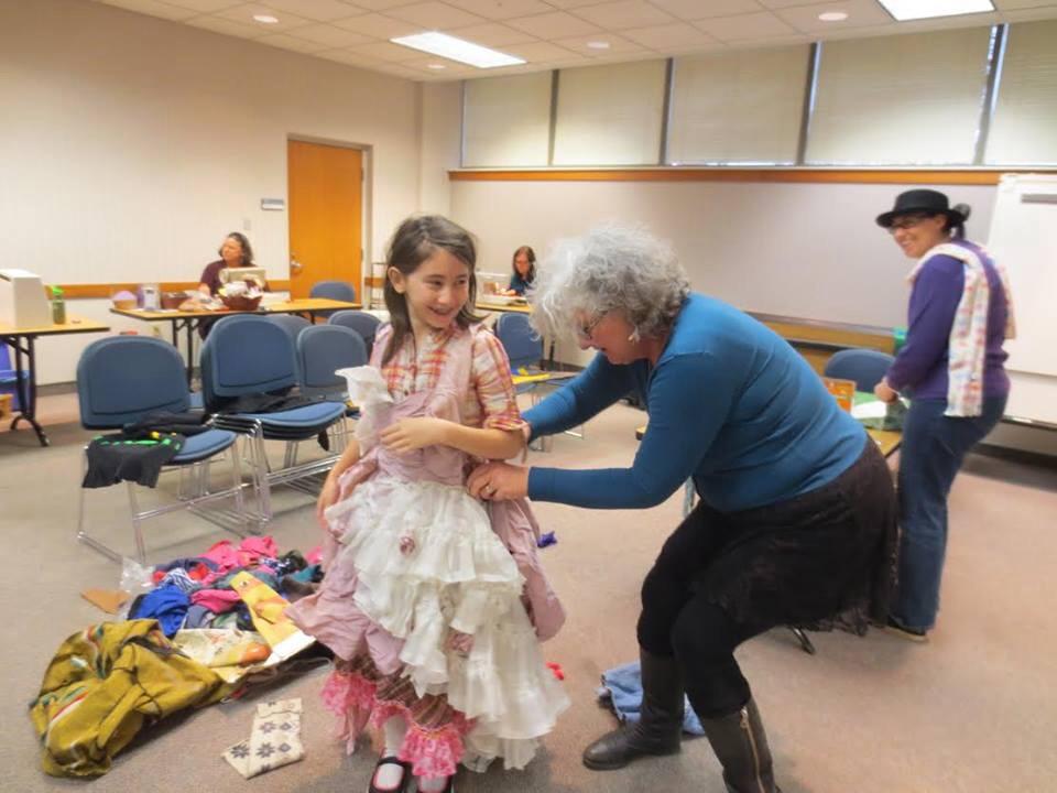 People helping a child create a costume from reused materials