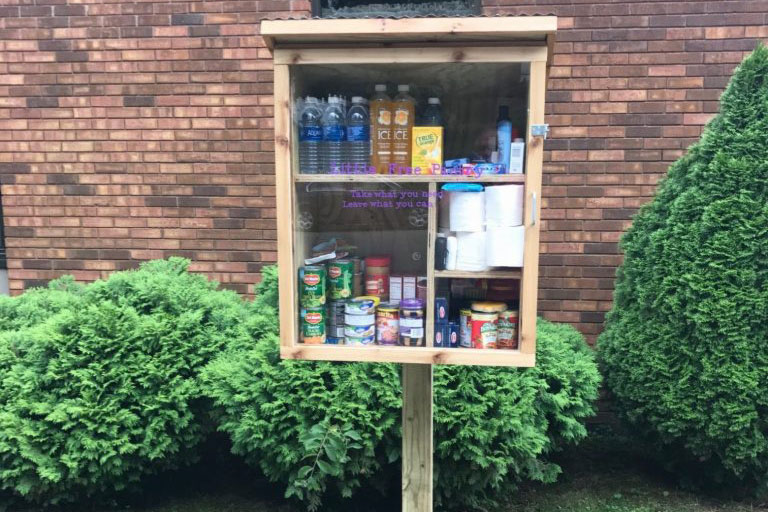 Outdoor pantry cabinet stocked with drinks, canned food and household supplies