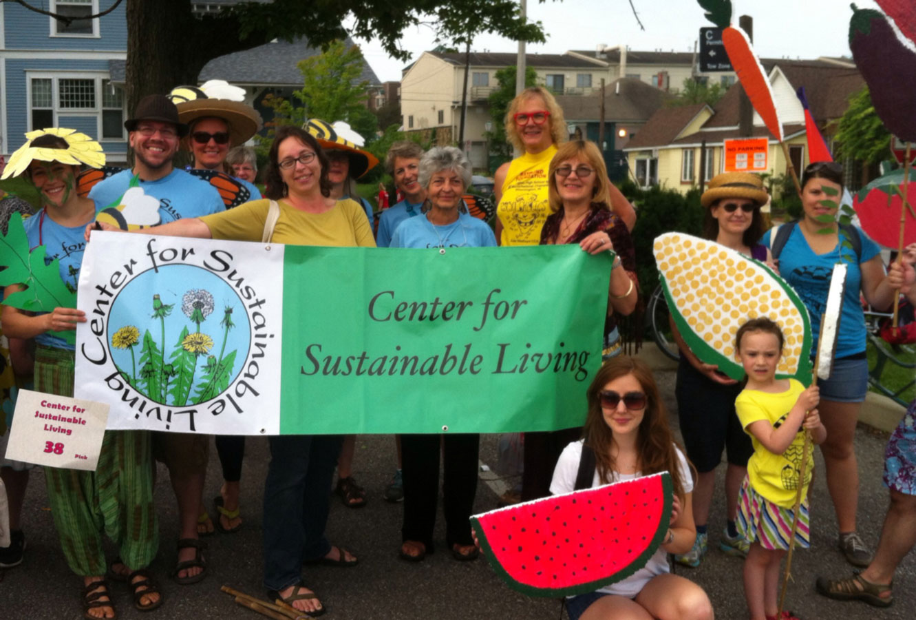 CSL participants holding a banner and handmade flowers and vegetables at a parade
