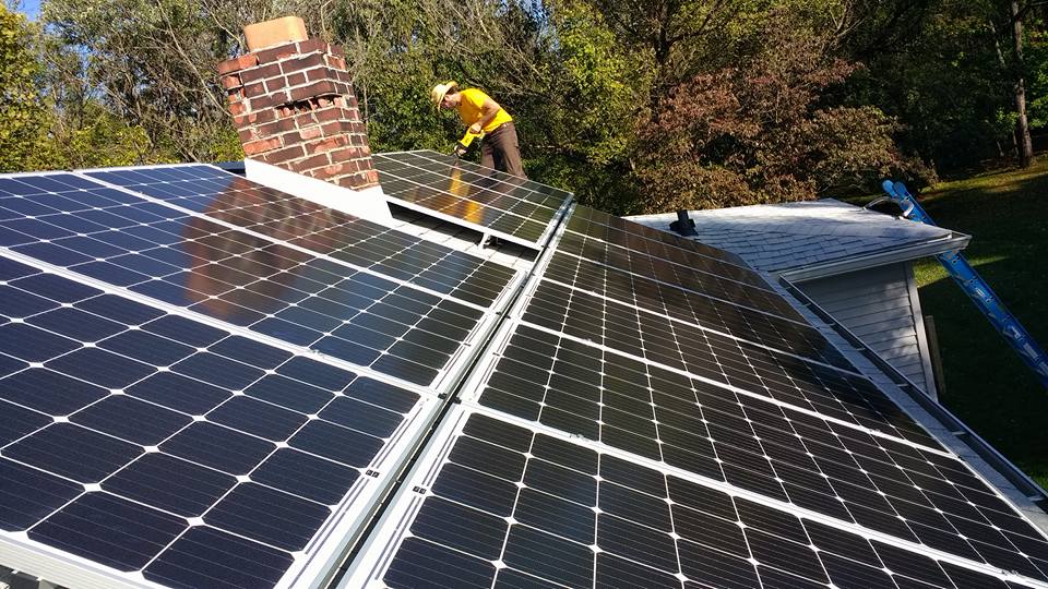 People installing solar panels on a roof